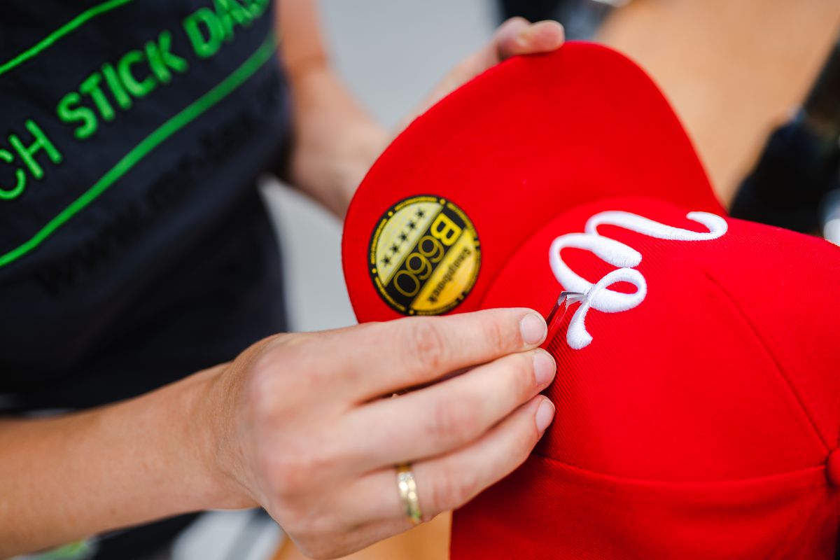 Bestickte rote Cap mit weißem Logo — Detailaufnahme