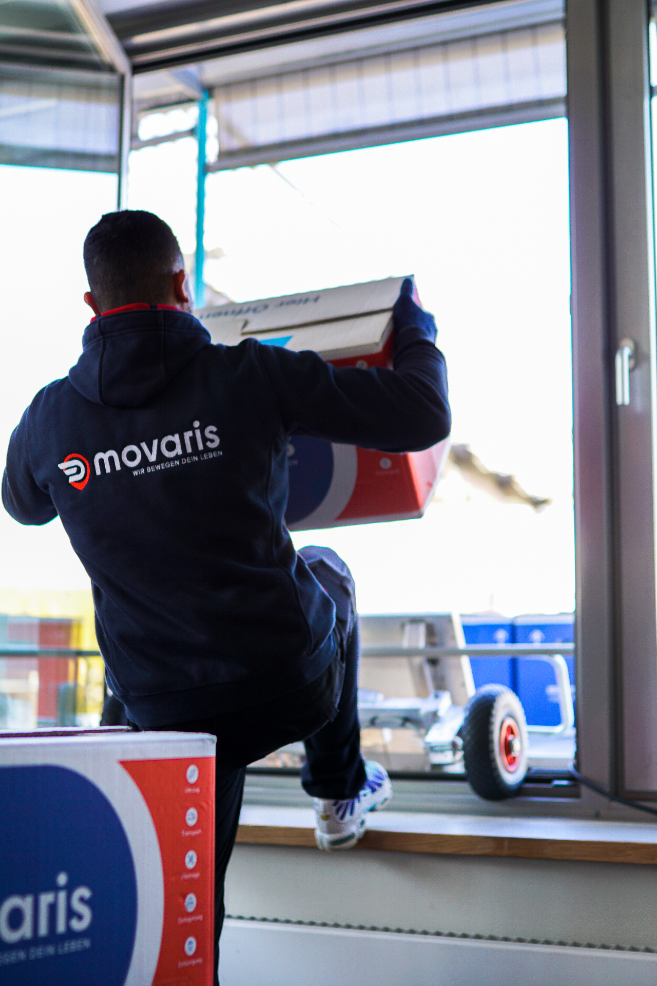 Movaris Mitarbeiter mit besticktem Hoodie beim Umzug